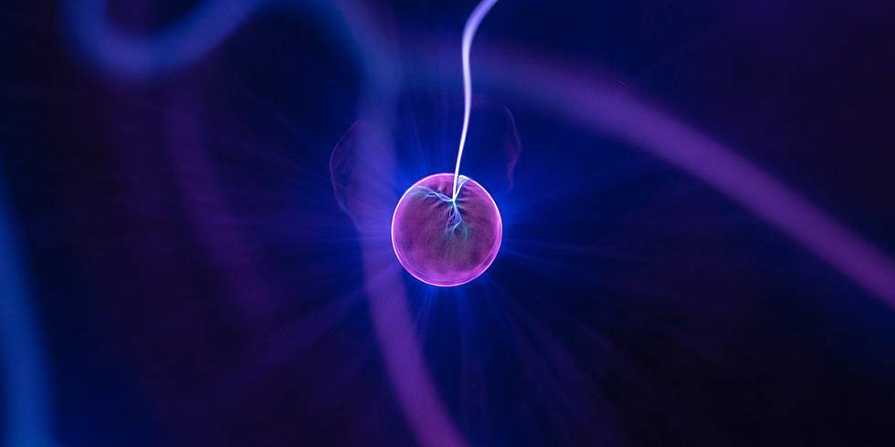 Violettes Computer-generiertes Plasmapartikel vor dunklem Hintergrund