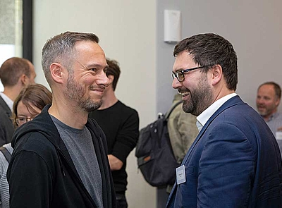 Sebastian Askar und Nicolas Zimmer von der Technologiestiftung Berlin unterhalten sich in der Pause